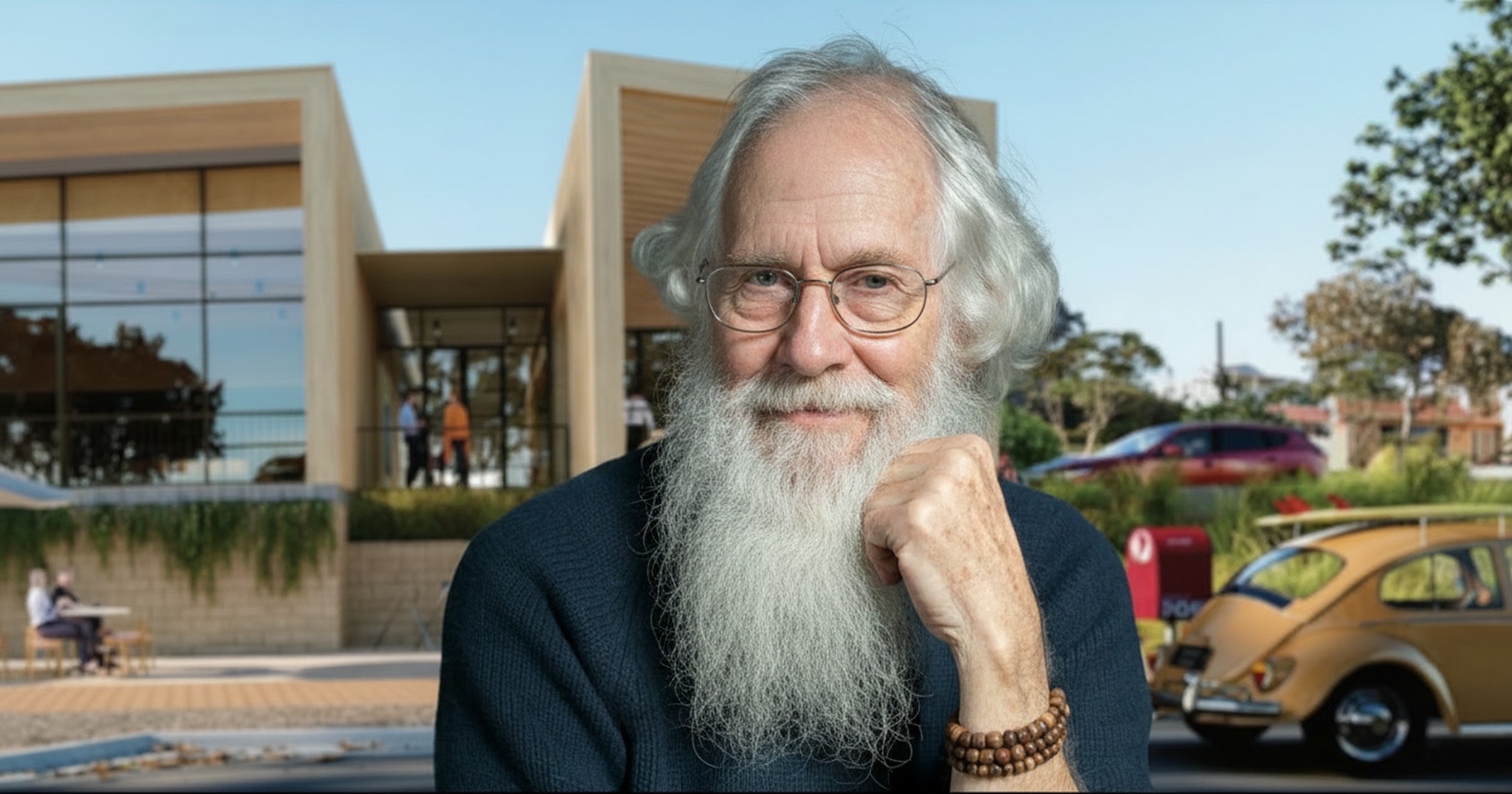 An elderly man with a long white beard and glasses facing the camera
